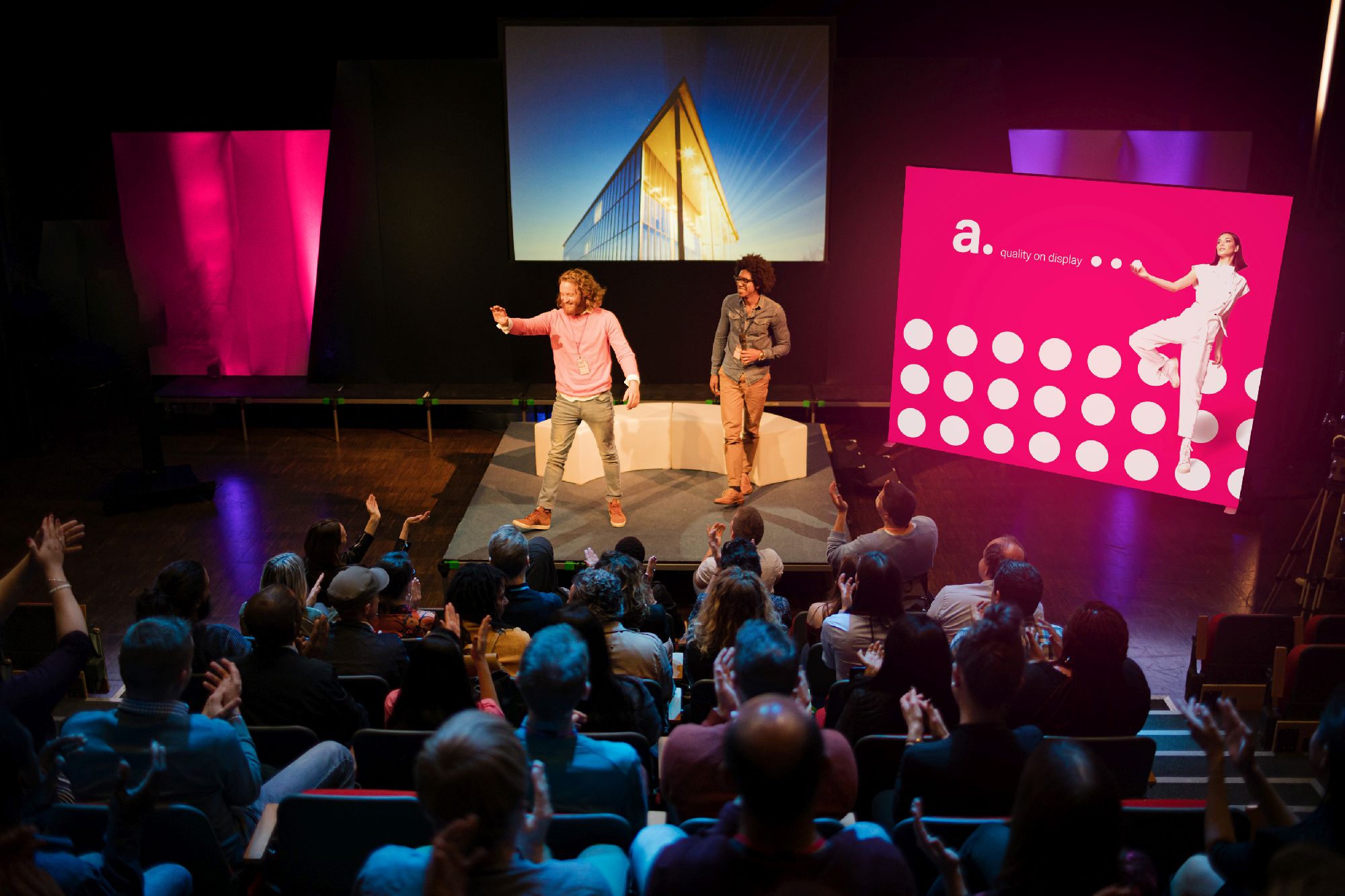 Prezenterzy na scenie na tle kasetonu LED